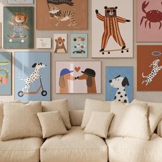 a living room filled with lots of pictures on the wall above a white couch and covered in pillows