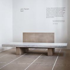 a bench sitting in the middle of a room with white walls and tile flooring