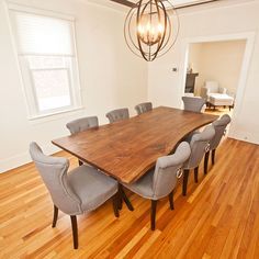 a dining room table with six chairs and a chandelier