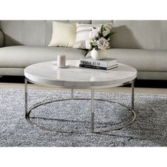 a white coffee table sitting on top of a carpeted floor next to a couch