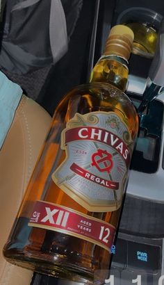 a bottle of chivas is sitting in the passenger seat