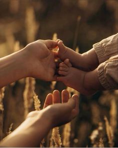 two people holding their hands in front of each other with the baby's hand