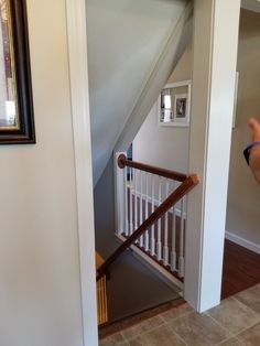 an open door leading to a hallway with white railing and wood banisters on either side