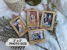 four wooden photo frames with christmas pictures hanging from them on top of a white blanket