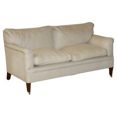 a white couch sitting on top of a hard wood floor next to a wooden leg