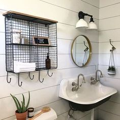 a bathroom with a toilet, sink and shelves on the wall next to each other