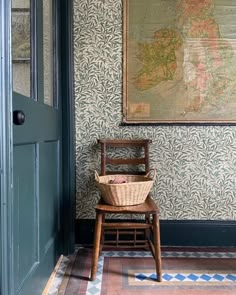 a chair sitting in front of a wall with a map hanging on it's side