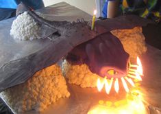 a dragon cake with lit candles on it