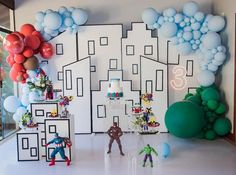 a room filled with balloons and toys in front of a cityscape wall mural