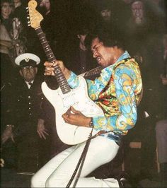 a man playing an electric guitar in front of a crowd