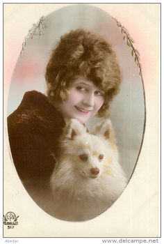 an old photo of a woman with a dog in her lap looking at the camera