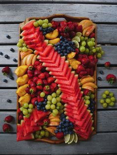 a wooden tray filled with lots of different types of fruit