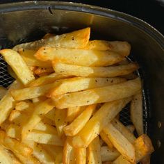 some french fries are in a basket on the stove top, and it looks like they have been cooked