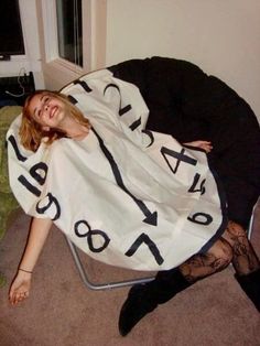 a woman laying on top of a chair covered in a blanket with numbers printed on it