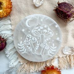 a white plate sitting on top of a table covered in flowers and plants next to an orange succulent plant