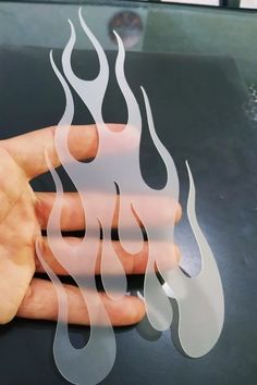 a person holding their hand on top of a table with flames in the middle of it