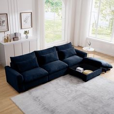 a living room with a sectional couch and coffee table on the floor in front of two windows