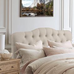 a bedroom with a bed, dresser and painting on the wall above it's headboard