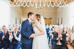 a bride and groom kissing in front of an audience