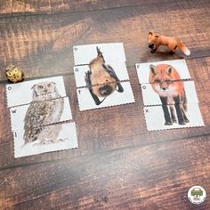 four stamps with different animals on them sitting on a wooden table next to a toy animal