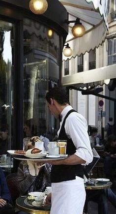 a man in an apron holding a plate with food on it