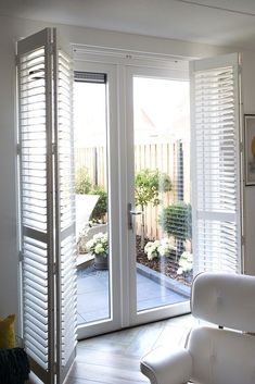 a living room with sliding glass doors and white furniture