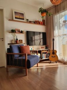 a living room filled with furniture and a flat screen tv on top of a wooden shelf