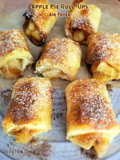 apple pie roll ups on a plate with powdered sugar sprinkled on top