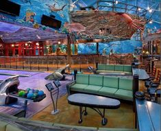 an indoor bowling alley with couches and tables