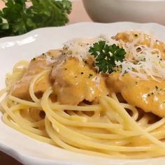 a white plate topped with pasta covered in sauce