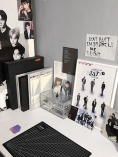 a desk with various items on it including a laptop, cd player and album covers