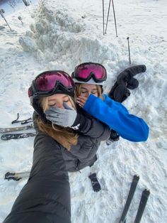 two women wearing skis and goggles in the snow