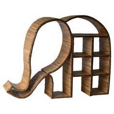 a wooden book shelf shaped like an elephant's tail with shelves on each side