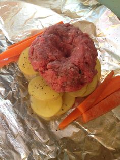 a hamburger and carrots on tin foil