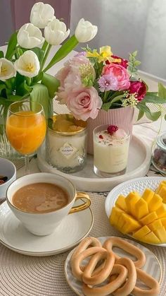 a table topped with plates filled with food next to cups and saucers covered in fruit