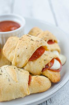 small sandwiches on a plate with dipping sauce