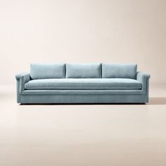 a blue couch sitting on top of a white floor