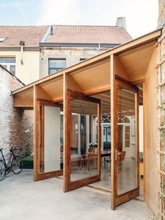 an open patio area with sliding glass doors on the outside and brick building in the background