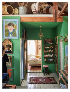 a room with green walls and pictures on the wall