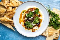 a white plate topped with food next to tortilla chips and cilantro