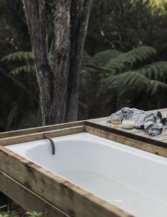 an outdoor bathtub in the middle of a wooded area