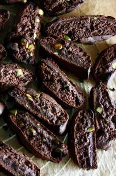 chocolate cookies with pistachios are on a piece of parchment paper