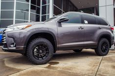 a gray toyota highland parked in front of a building