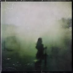 a blurry image of a person walking in the fog