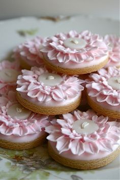 pink decorated cookies are arranged on a plate