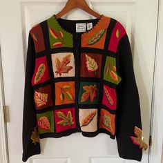 a sweater with leaves on it hanging from a door