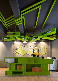 the interior of an office with green shelving and yellow bookshelves on the ceiling