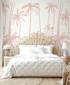 a bedroom with pink palm trees painted on the wall and wicker furniture in the foreground