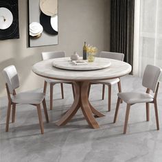 a white marble dining table with four chairs and a vase on the table in front of it