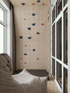 a living room filled with lots of furniture and climbing wall mounted to the side of a building